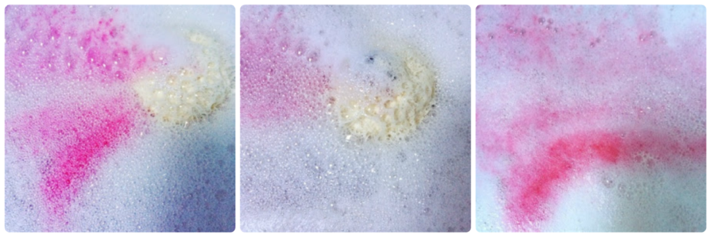 Extreme close up of Lush Rose Bombshell Bath Bomb fizzing in water with pink coming from it