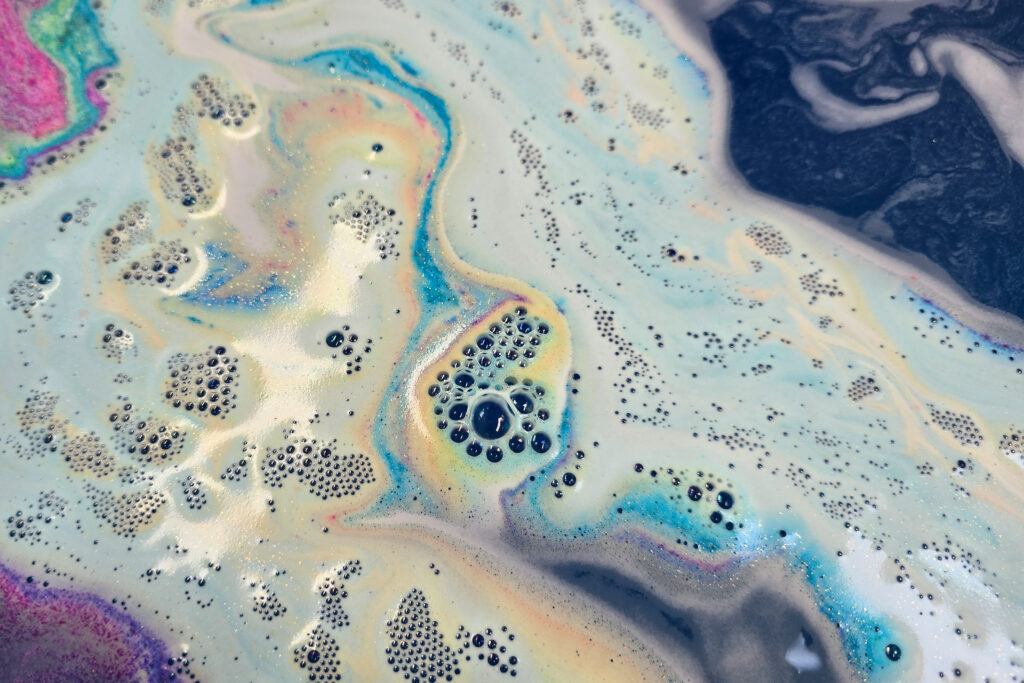 Photo taken by Jordanne / Ofaglasgowgirl of Lush Intergalactic Bath Bomb in the water, fizzing with swirls of blue, yellow and pink plus glitter 