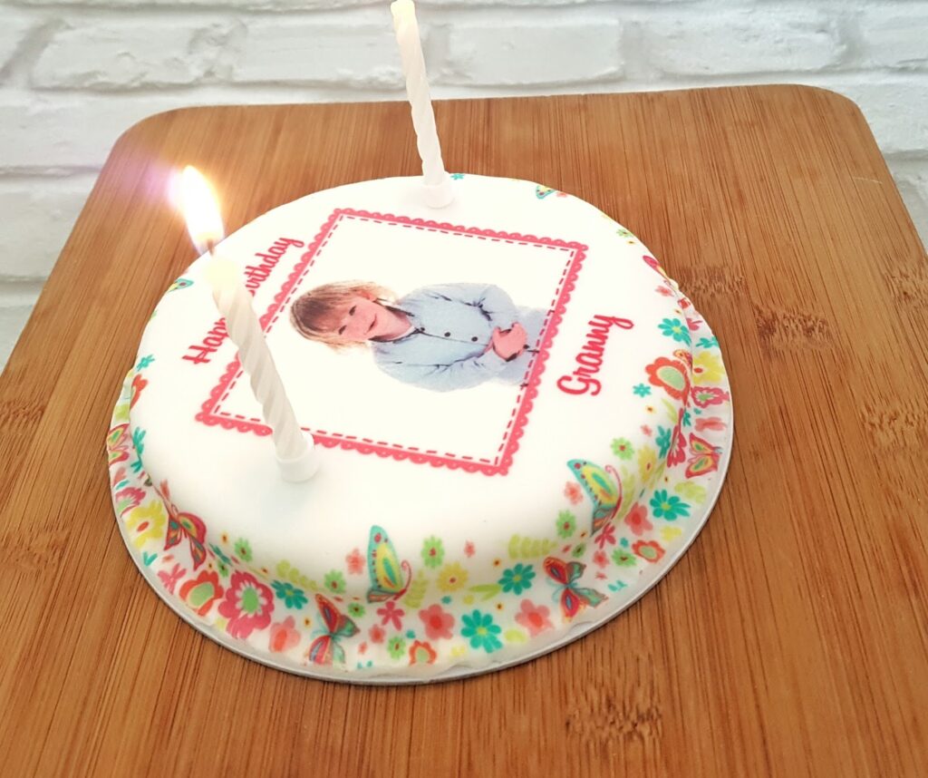 A side view of the bakersday cake with two candles in it