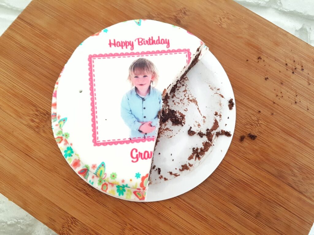 A birds eye view of a bakersday 5 inch cake with a section cut out
