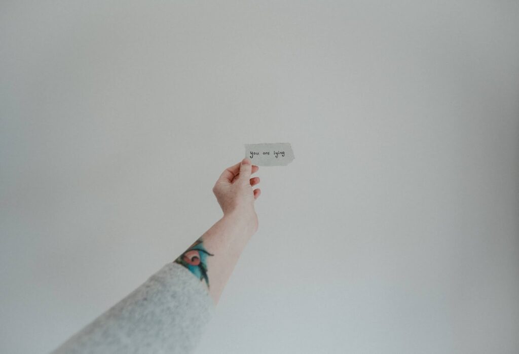 The Girl That Lied - TW talk of sexual assault on Thelifeofaglasgowgirl.co.uk Stock image from unsplash of someone holding a piece of paper that says "you are lying"