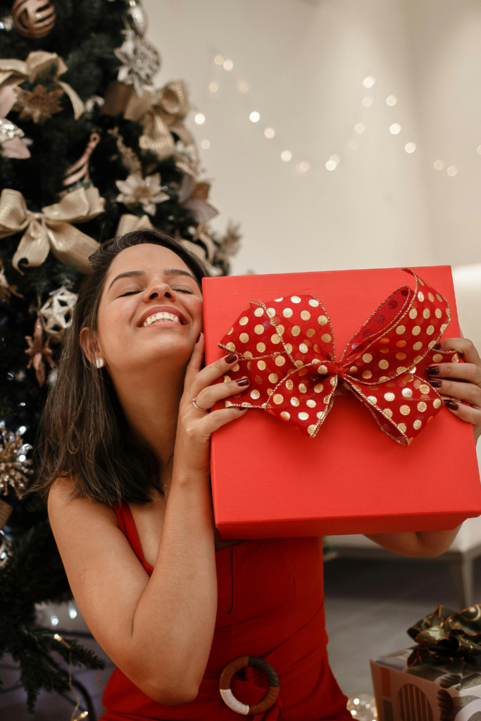 A stock photo from Canva of a woman holding a red gift box