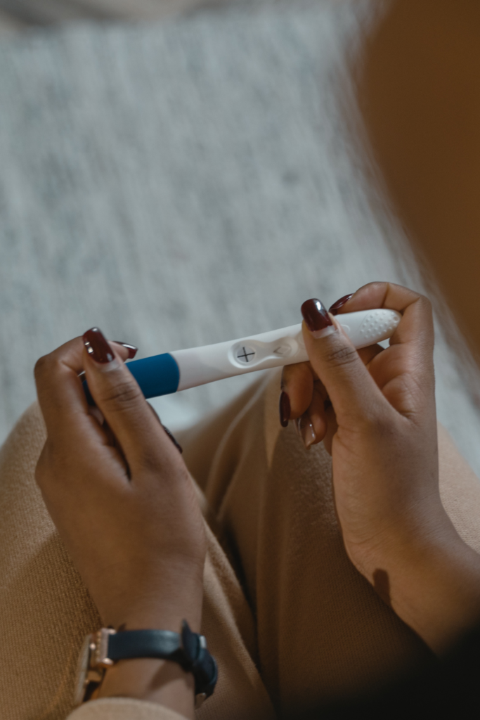 A stock photo from Canva of a woman holding a positive pregnancy test