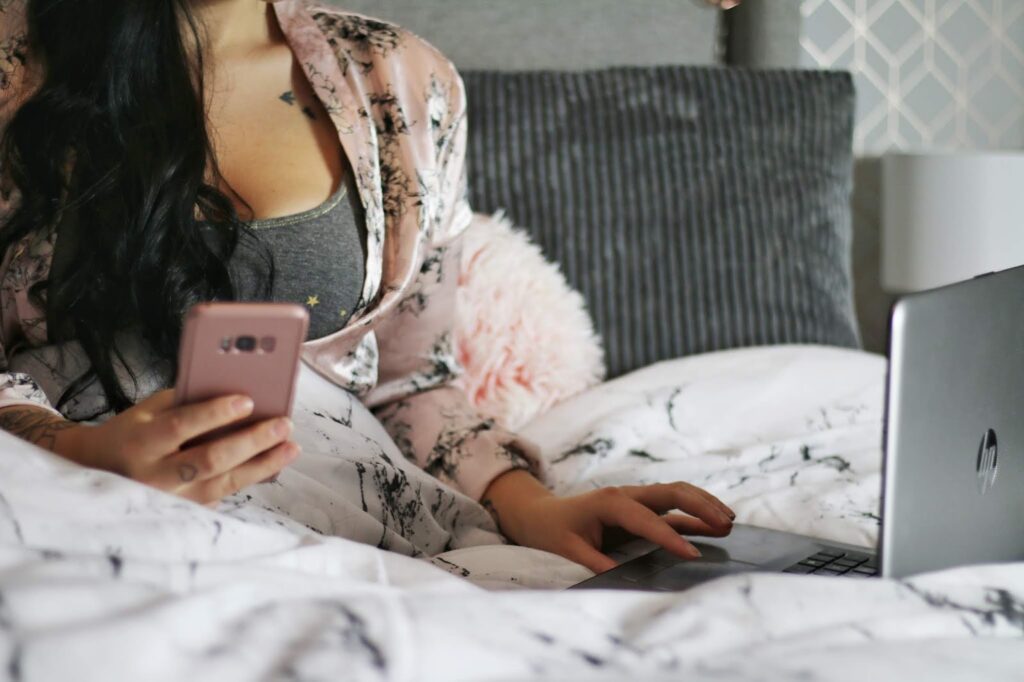 girl sitting in bed on phone girl sitting in bed on phone