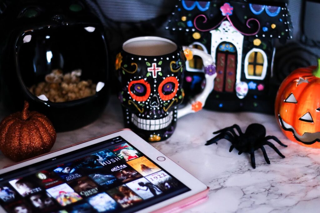 Horror Month: What's On My Watch List - Close up photo of a skull mug next to spider and ipad