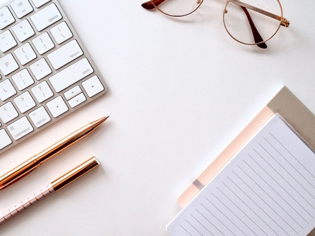 Instagram Tips and Tricks - Flat lay photo of a desk with some notepads and a silver keyboard