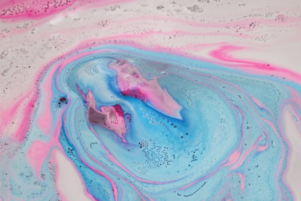 Close up of Monsters' Ball fizzing out pink and blue in the water