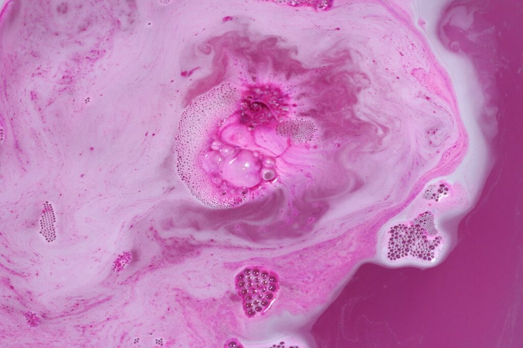 Close up of Monsters' Ball fizzing out pink in the water