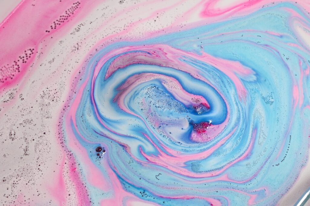Close up of Monsters' Ball fizzing out pink and blue in the water