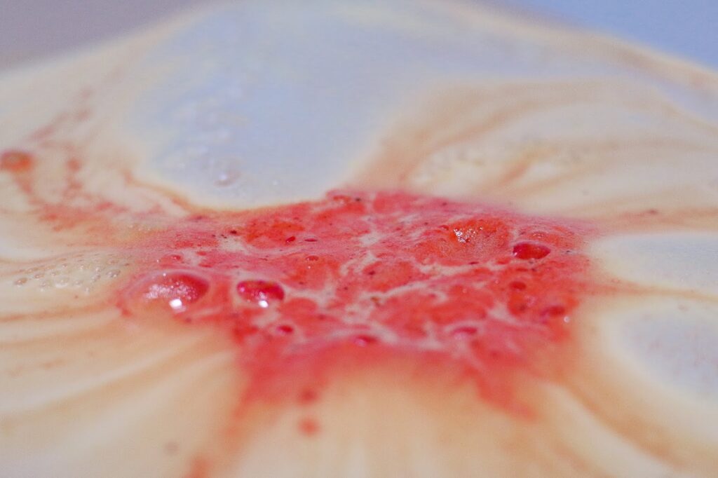 Extreme close up of Pumpkin Pumpkin bath bomb from lush in the water fizzing with white, orange and green coming out of it on thelifeofaglasgowgirl.co.uk