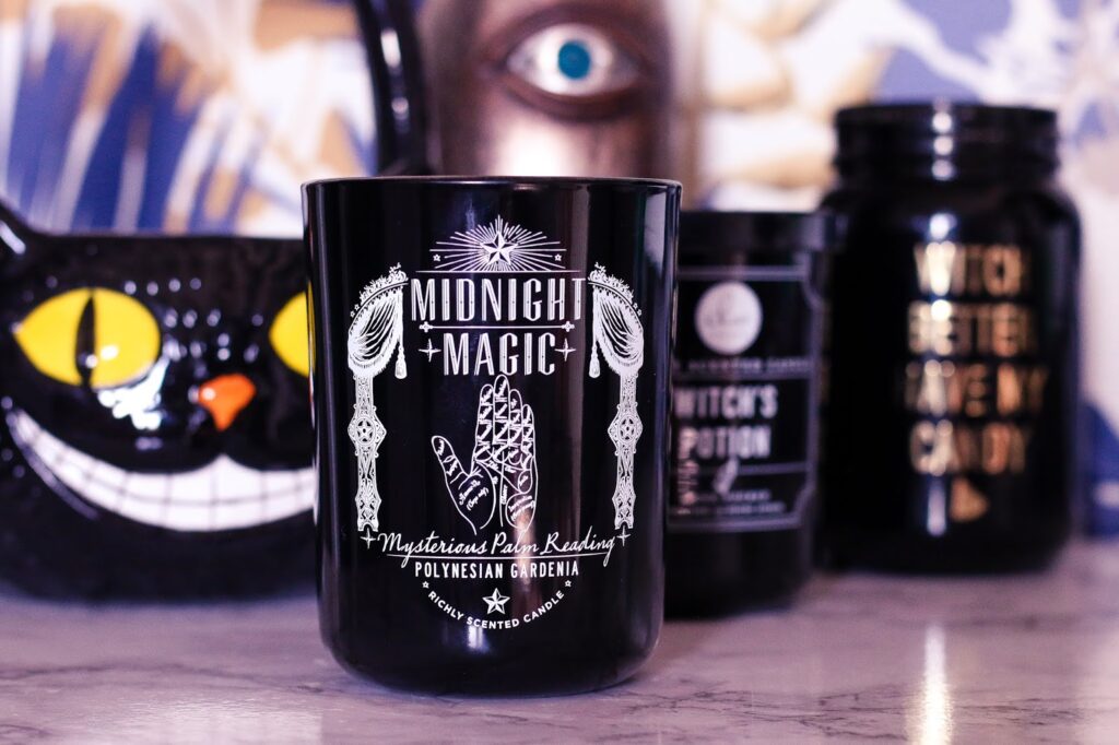 Halloween inspired candles close up of a candle that had midnight magic printed on it with the illustration of a palm reading