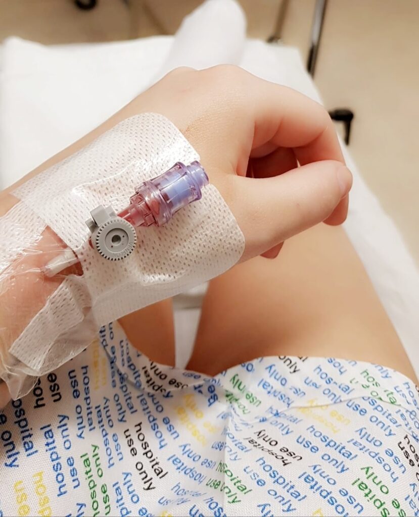 Close up photo of ofaglasgowgirl with a cannula in her hand wearing a hospital gown