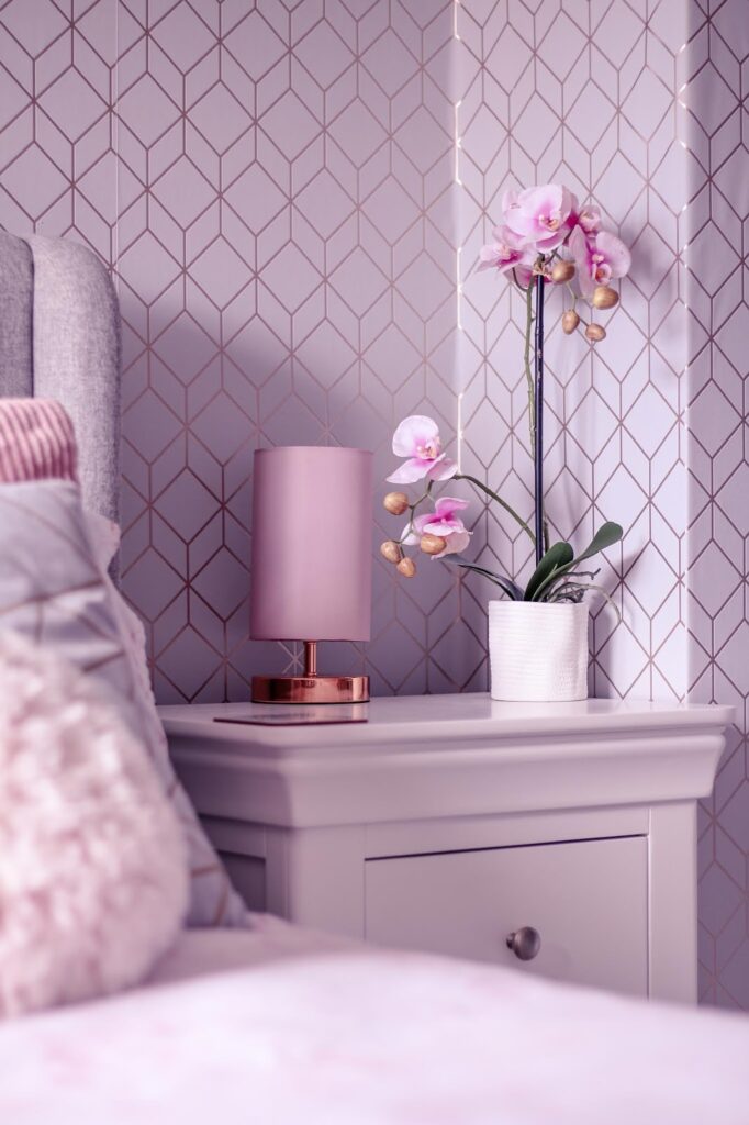 Photo by Ofaglasgowgirl of a white bedside table next to a grey bedfrane with pink lamp sitting on the bedside table