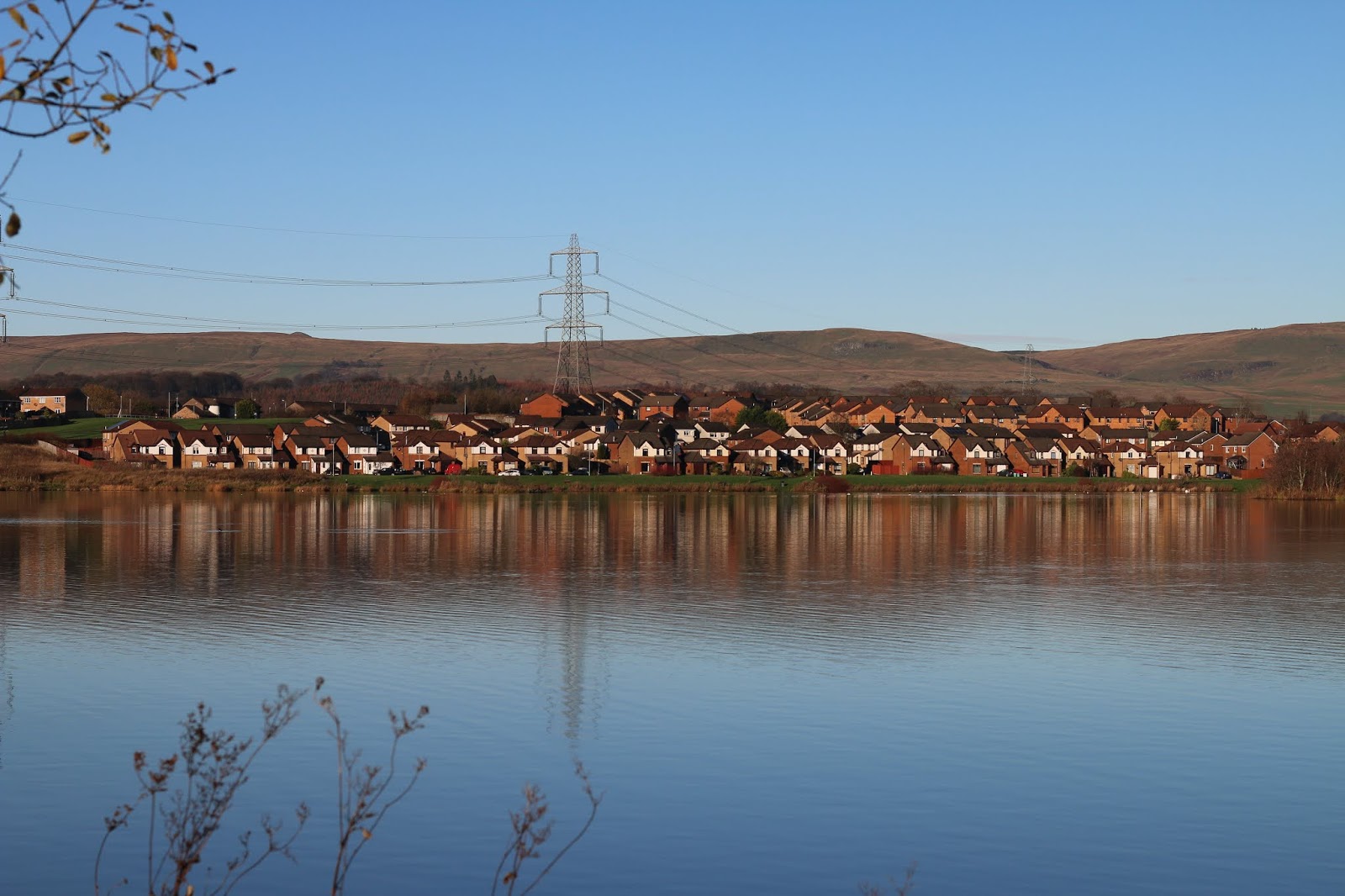 Photo of a lake with houses in the distance by Jordanne Lee Creative Photo of a lake with houses in the distance by Jordanne Lee Creative