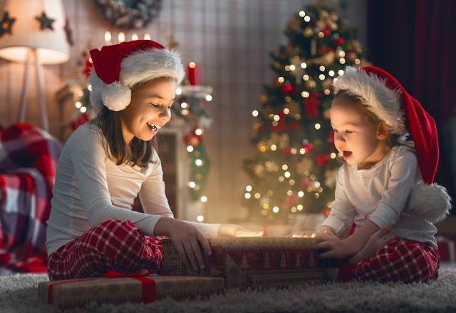 Photo from Adobe stock of two children opening a magical christmas gift box