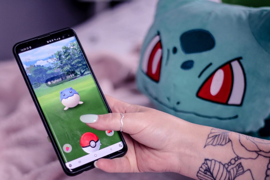 Close up photo of girl holding a phone which displays the Pokémon Go app