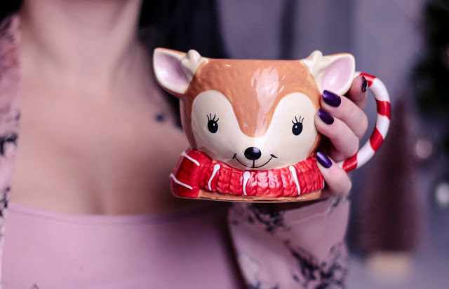 Close up of a woman holding a christmas mug