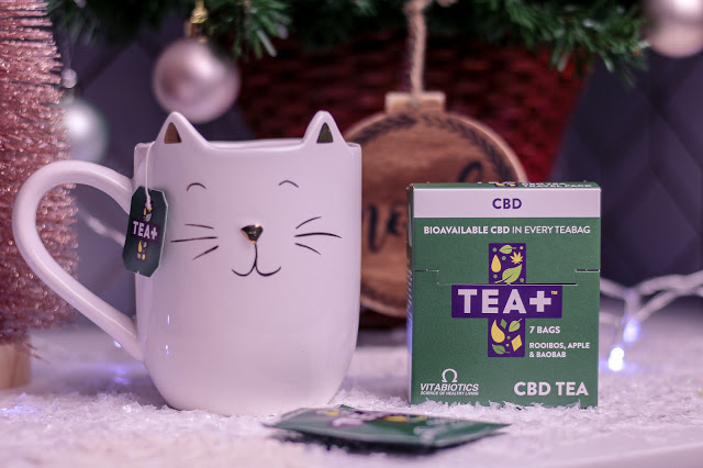 Close up of a white cat mug and the Tea+ CBD tea