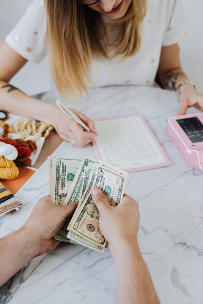 Financial Planning- Stock photo from pexels Karolina Grabowska of a woman and man counting money at a white table