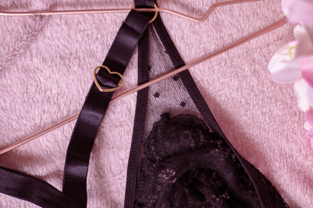Tutti Rouge Lingerie - The black Hallie bodysuit lingerie on a pink blanket