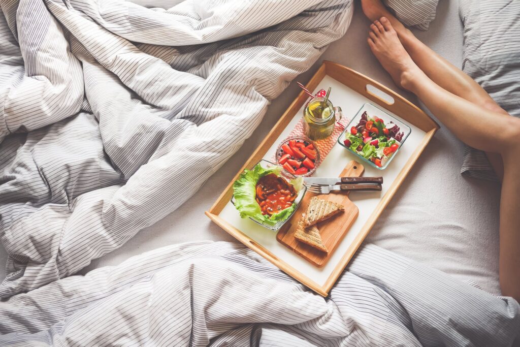 Stock photo on Pexels by picjumbo.com of a woman in bed with a tray of breakfast foods