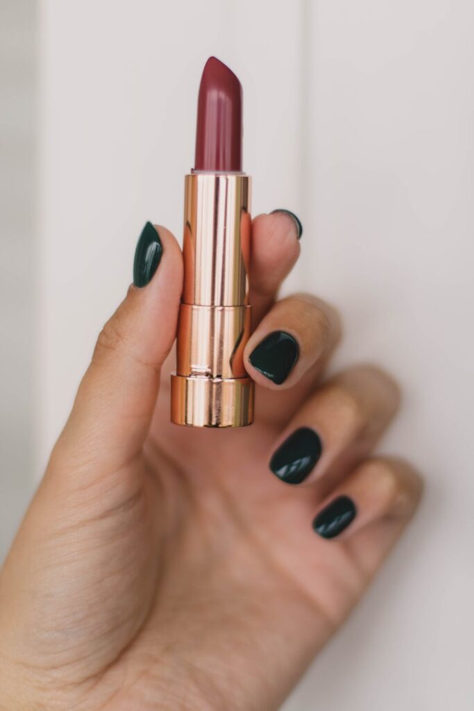 Blog post ideas - Stock photo of a woman holding a red lipstick from pexels by Kristina Paukshtite