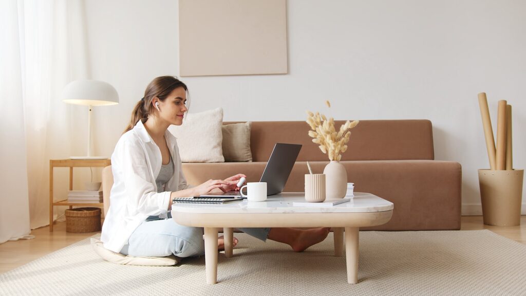 Blogging retweet accounts - Stock photo from pexels of a woman sitting on the floor with a laptop on a coffee table by Artem Podrez