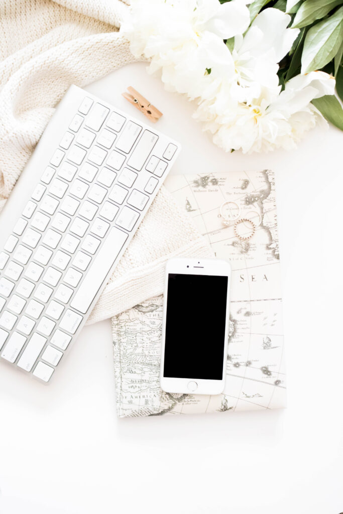 Stock photo from Grill boss stock images of a silver keyboard on a white desk with white flowers and some rings and phone
