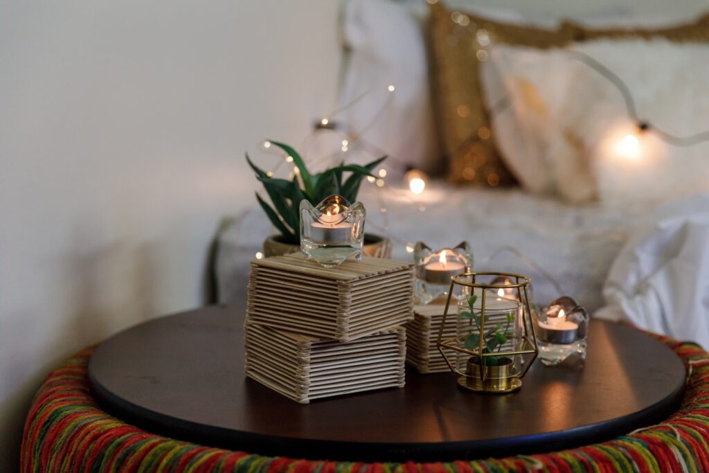 stock photo from Unsplash by Shashi Chaturvedula of candles on a table and white bed in the background