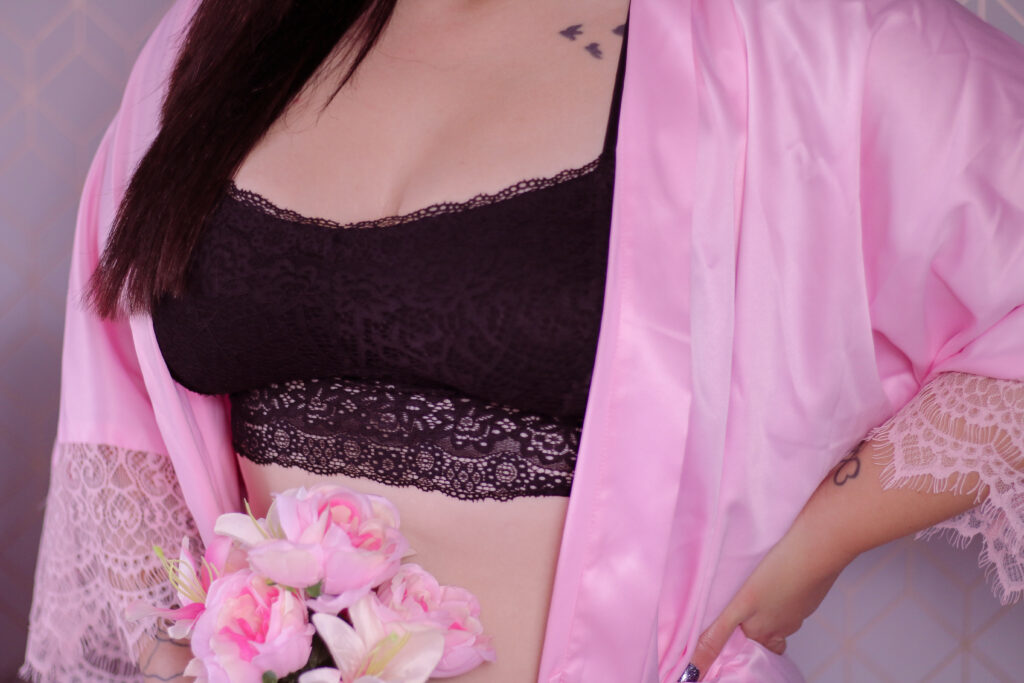 Close up of Jordanne wearing the Sexy Pink Satin & Lace Long Dressing Gown and Black Supportive Longline Lace Bralette Bra from IDentity Lingerie