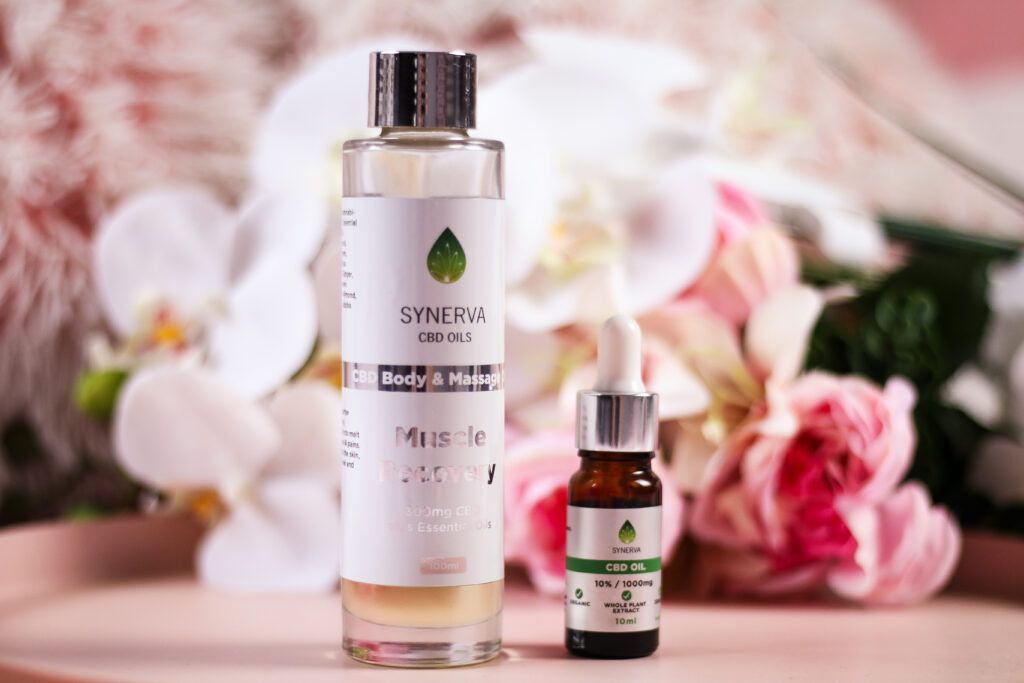 A close up photo of two Synerva CBD Oils products. Their muscle recovery CBD body and massage oil is on the left and their 10% 1000mg CBD oil is on the right