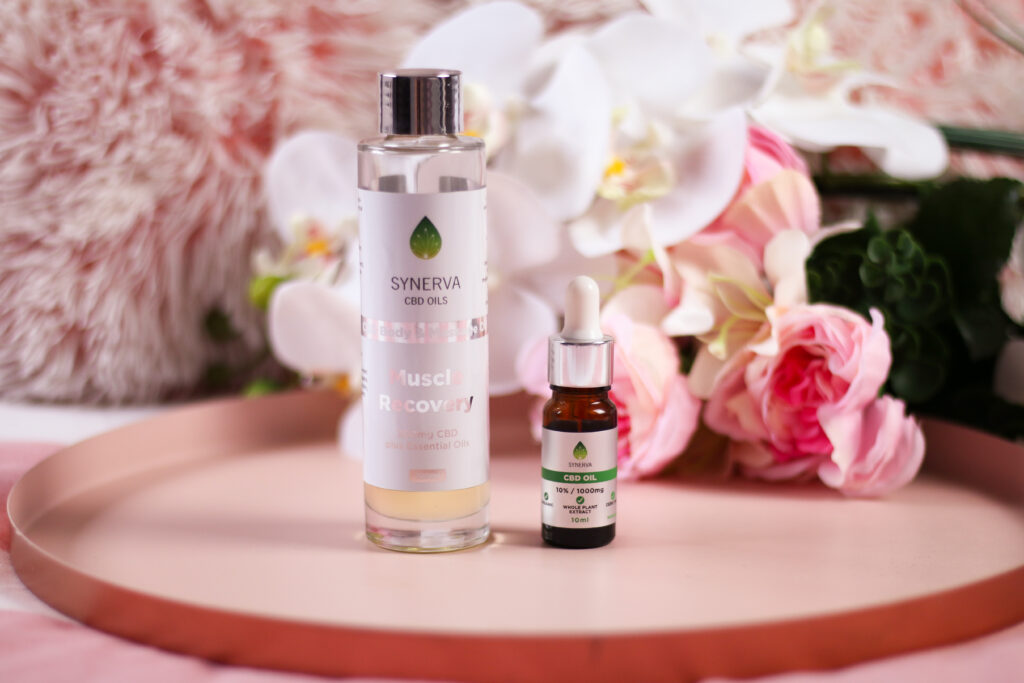A close up photo of two Synerva CBD Oils products. Their muscle recovery CBD body and massage oil is on the left and their 10% 1000mg CBD oil is on the right
