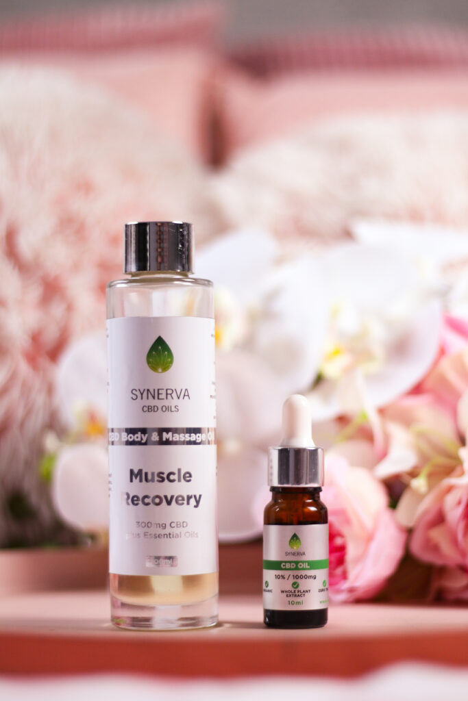 A close up photo of two Synerva CBD Oils products. Their muscle recovery CBD body and massage oil is on the left and their 10% 1000mg CBD oil is on the right