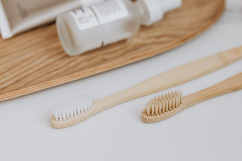 Stock photo from pexels by Karolina Grabowska of two bamboo tooth brushes on a white table top
