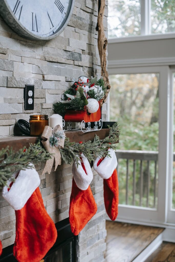 Stock photo from pexels by Any Lane of three red stocking hanging on a brick fireplace