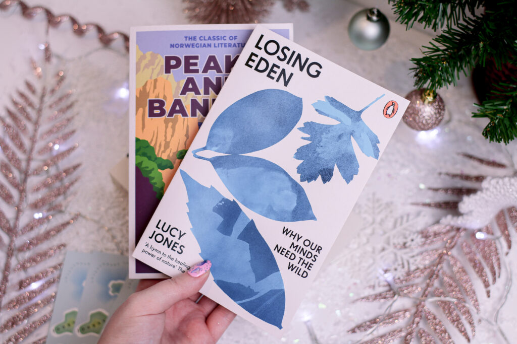 Close up photo of Jordanne holding two books from Adventurous Ink subscription service