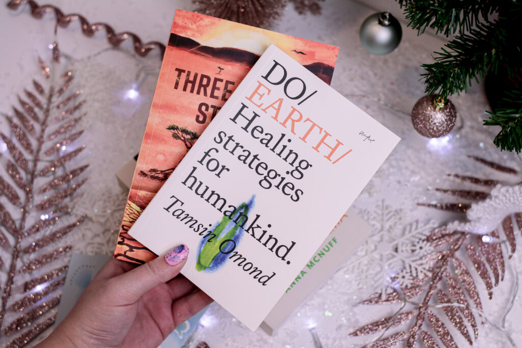Close up photo of Jordanne holding two books from Adventurous Ink subscription service
