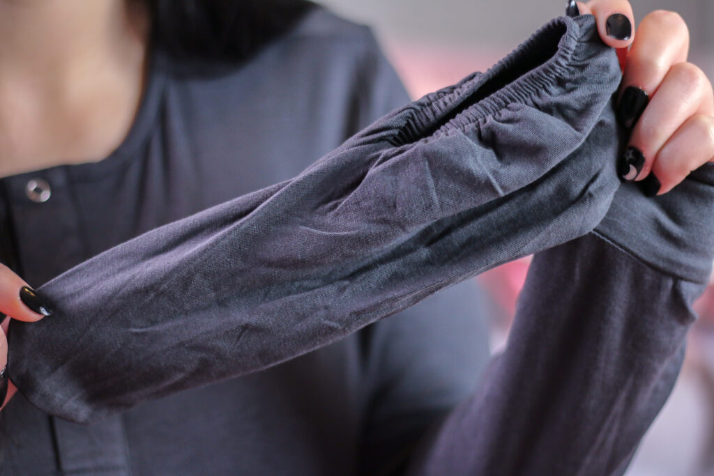 Close up photo of Jordanne wearing sleepwear from We Drifters and holding up one of the socks that comes with the sleepwear