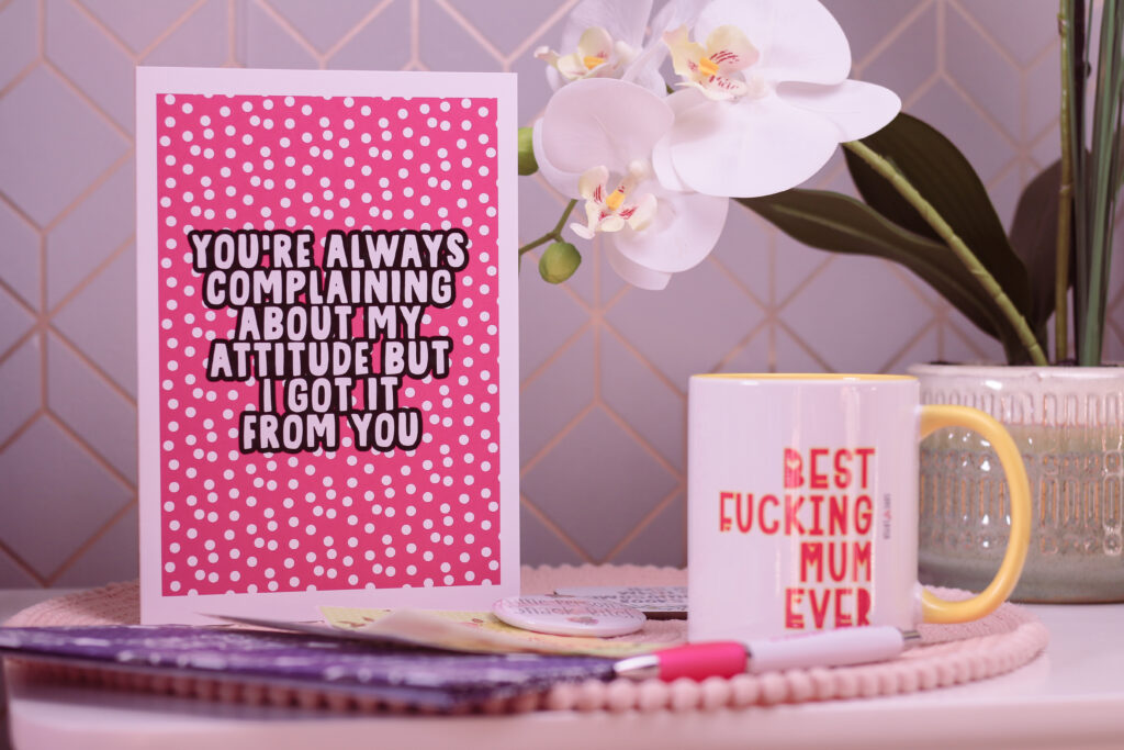 Close up photo of a pink Mother's Day card from Love Layla Designs. The card reads "You're Always Complaining About My Attitude but I got it from You"