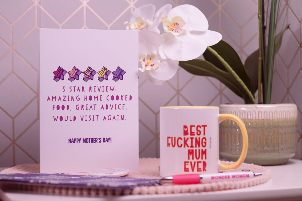 Close up photo of a purple and white Mother's Day card from Love Layla Designs. The card reads "5 star review: Amazing home cooked food, great advice. would visit again"