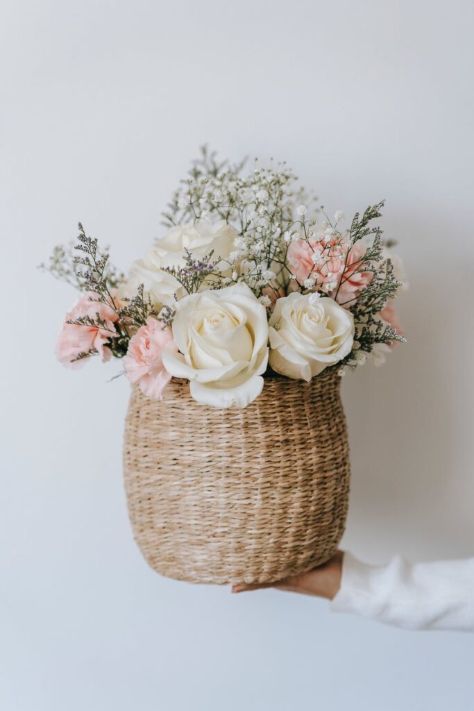 Stock photo from Pexels by Teona Swift of a wicker basket filled with white roses and pink peonys.