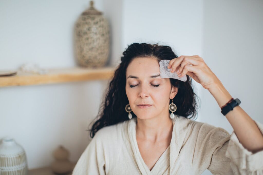 Stock photo from pexels by Elina Fairytale of A Woman Using a Gua Sha on Her Face with Her Eyes Closed