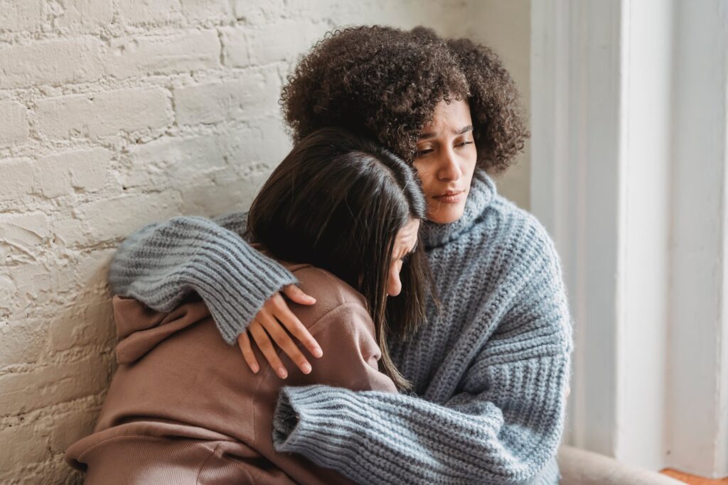 Stock photo from Pexels by Liza Summer of two women hugging as one cries