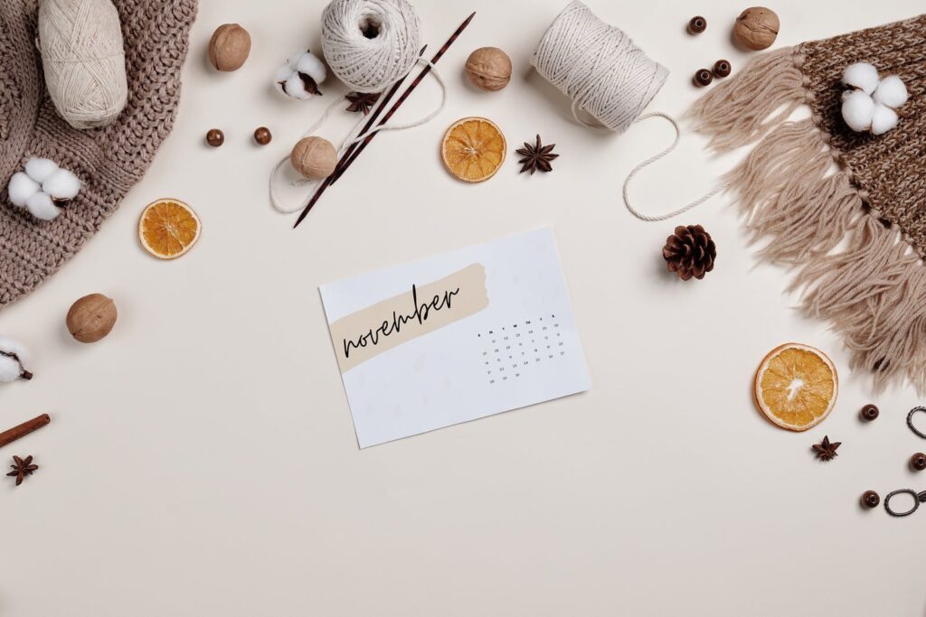 Stock photo from pexels by Boris Pavlikovsky of a Piece of a Calendar on the Table Top with Yarn Rolls and Sliced Fruits