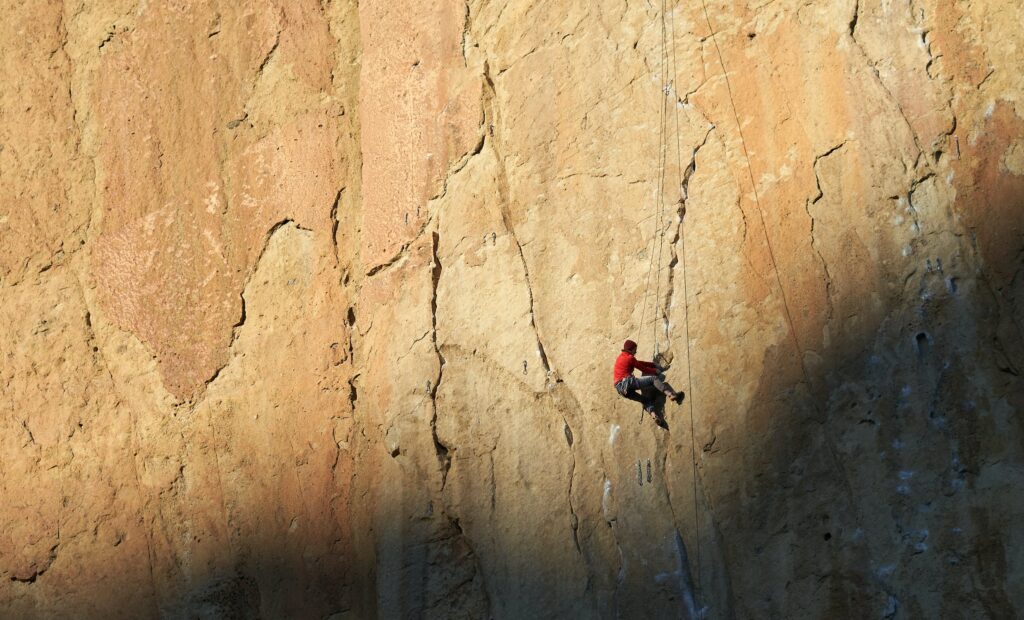Stock photo from Pexels by ArtHouse Studio of a man rock climbing a cliff
