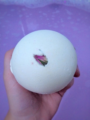 Close up of woman holding Lush Rose Bombshell Bath Bomb