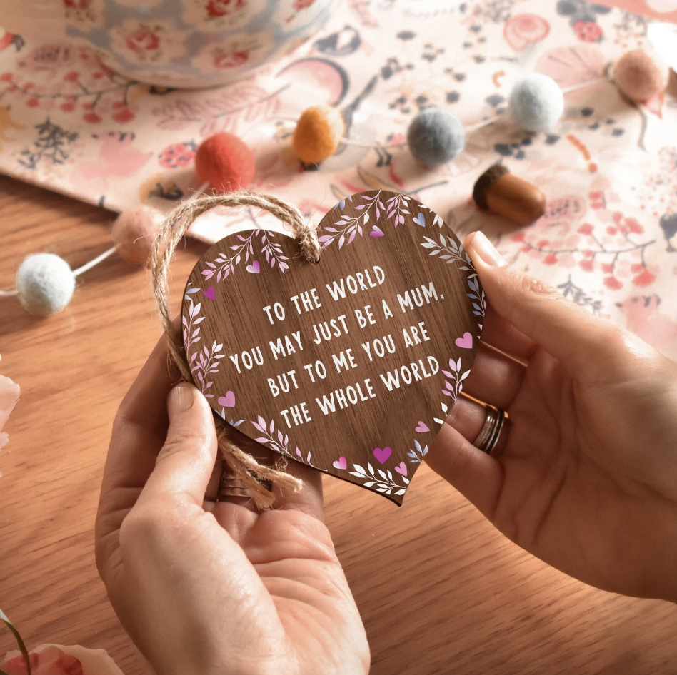 Photo by Manta Makes on Etsy of a wooden heart that has a quote reading "to the world you may just be a mum. But to me you are the whole world"