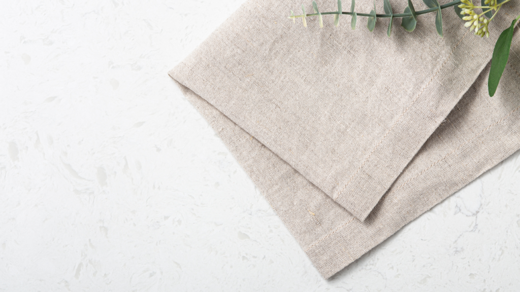 Stock photo from Canva by everydayplus at Getty Images of a beige cloth napkin on a white table