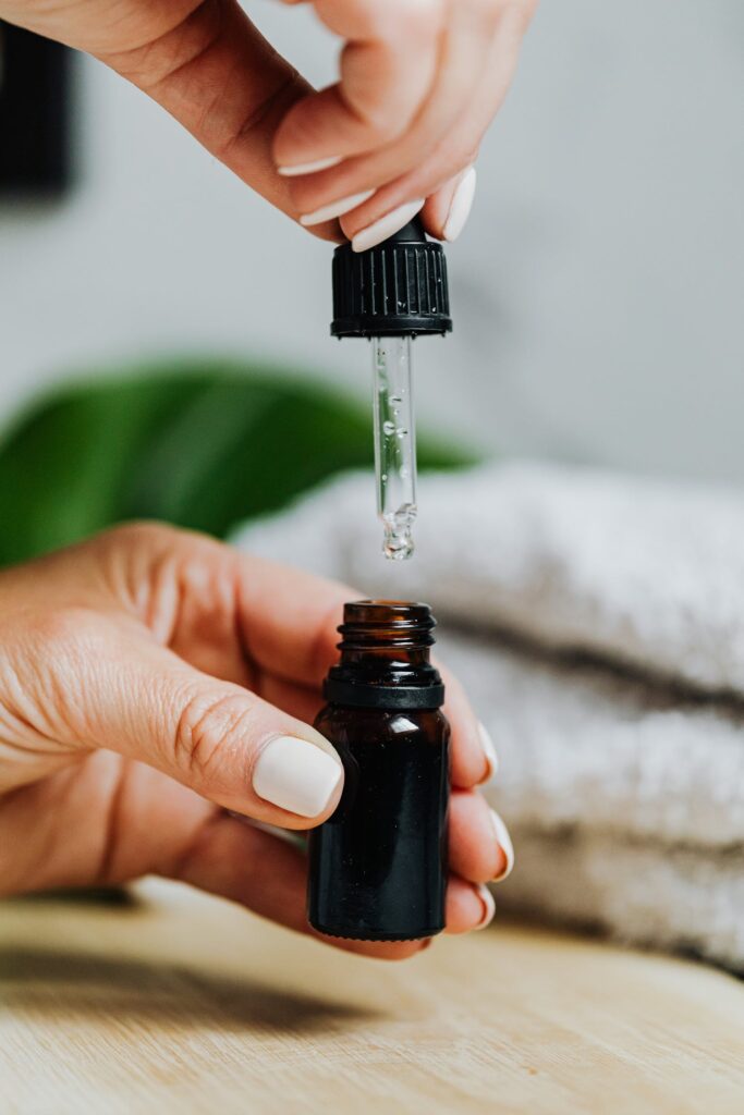 Stock Photo from Pexels by Karolina Grabowska of a person holding a black glass bottle with dropper