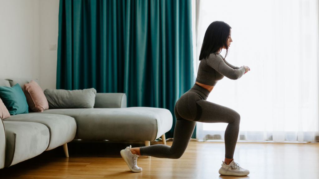 Stock photo from Canva by avanti_photo of a woman wearing grey gym clothing doing a lunge in a living room